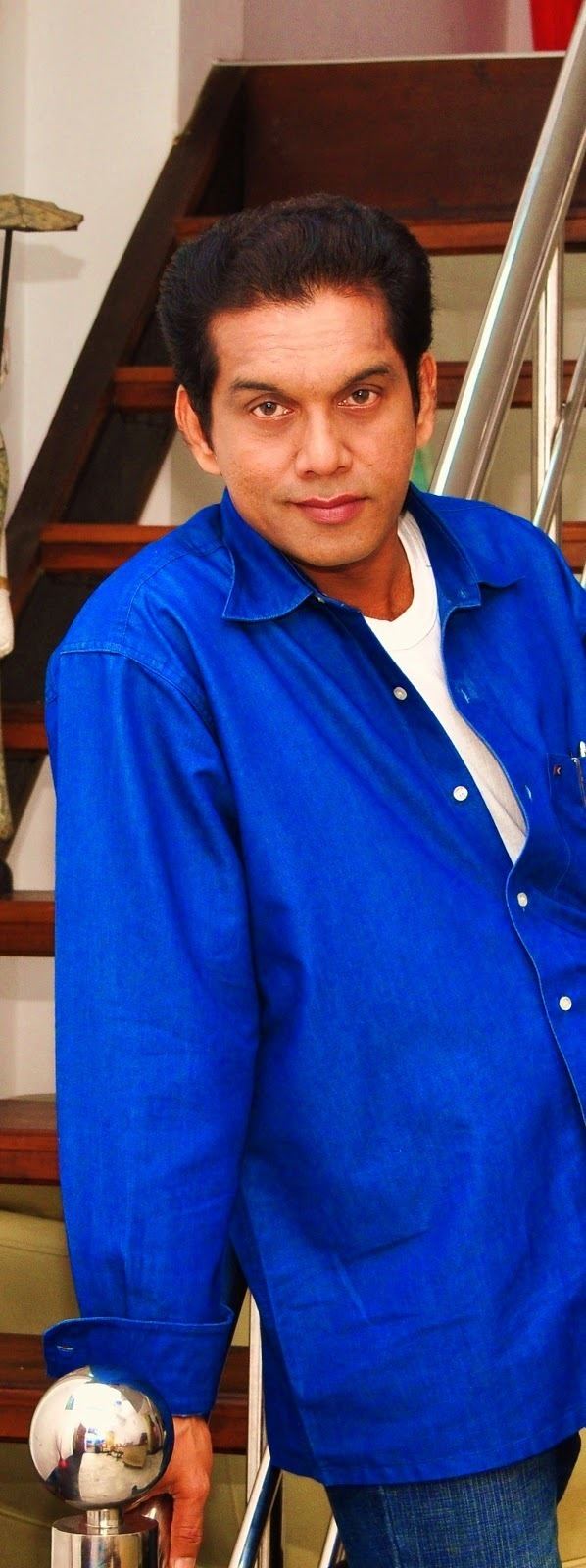 Kamal Addararachchi smiling while wearing blue long sleeves and jeans