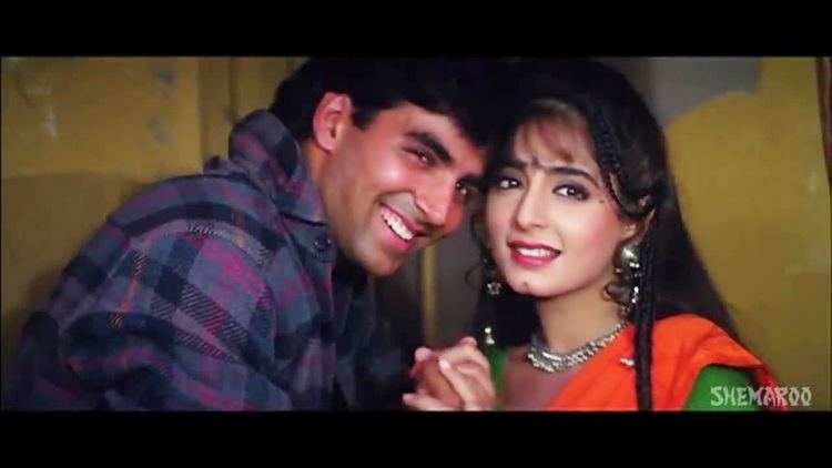Kanchan wearing a green and orange oufit and Akshay Kumar wearing a checkered polo while holding hands