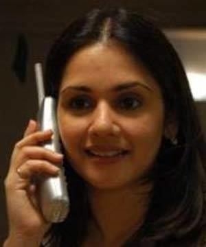 Kartika Rane smiling and holding a telephone
