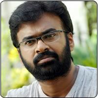 Karu Pazhaniappan with mustache and beard while wearing eyeglasses and white shirt