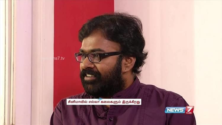 Karu Pazhaniappan in one of his interviews wearing eyeglasses and violet long sleeves