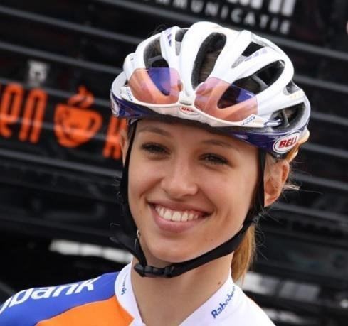 Katarzyna Niewiadoma smiling while wearing a helmet and white, blue, and orange jersey