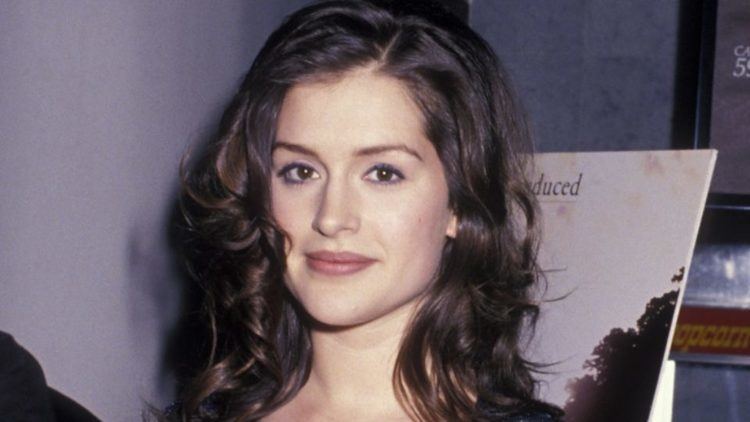 Kate Fischer with a tight-lipped smile and curly hair