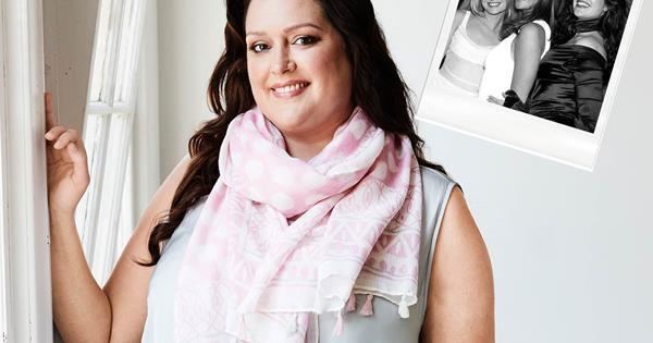 Kate Fischer smiling while wearing a gray sleeveless blouse and pink scarf