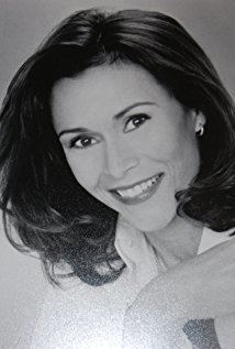 Kate Jackson smiling while wearing a blouse and earrings