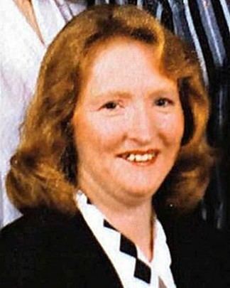 Katherine Knight smiling, with wavy blonde hair and wearing a white and black blouse.