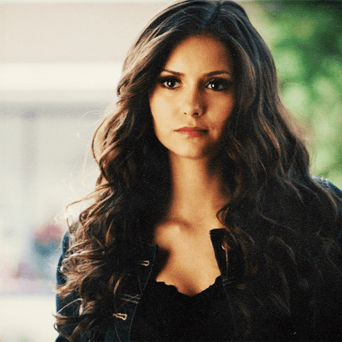 Katherine Pierce in her curly hair while wearing black jacket and black inner top