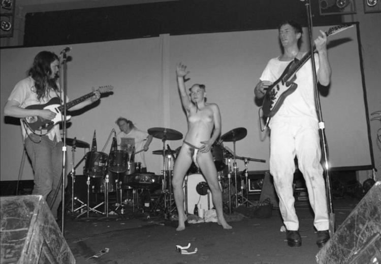 Kathleen Lynch is dancing naked while the band of Butthole surfers is performing
