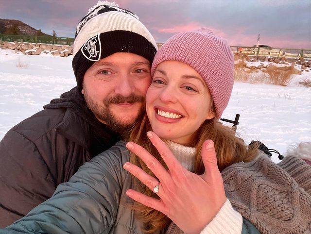 Katie Amis smiling with her boyfriend, Nick Nicotera, and showing her finger with the engagement ring given to her by Nick