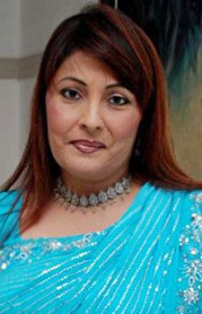 Kavita Kapoor smiling closed mouth and wearing a silver necklace and a sky blue dress.