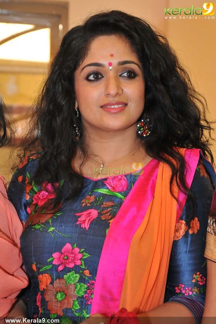 Kavya Madhavan wearing a floral dress and earrings