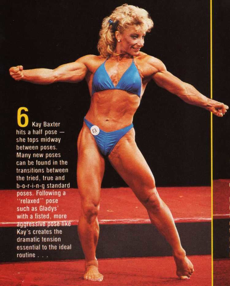 Kay Baxter in a half pose with both of her arms stretched sideward while wearing a light blue bikini