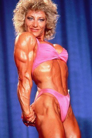 Kay Baxter flexing her muscles while wearing a pink bikini