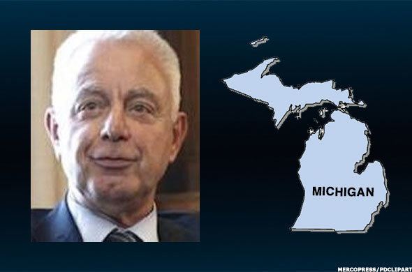 On the left, Kenneth Dart wearing a black coat, white long sleeves, and necktie while on the right is the map of Michigan.