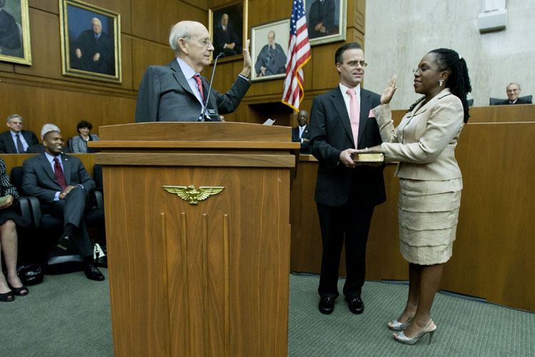U.S. Supreme Court Justice Stephen Breyer (left) administers the oath of office to U.S. District Court Judge Ketanji Brown Jackson as her husband, Patrick Jackson, holds the Bible during an official Investiture ceremony on May 9, 2013. Stephen wearing a gray coat, Patrick wearing a black coat while Ketanji wearing an off-white long sleeve blouse and a skirt.