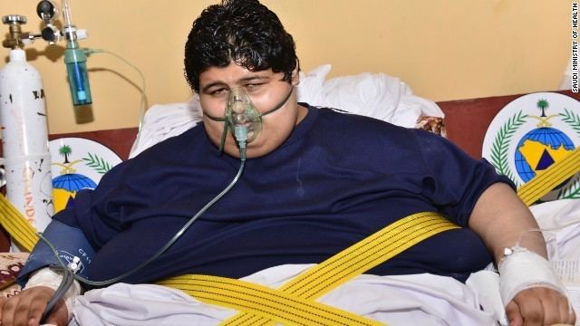 Khalid Bin Mohsen Shaari while laying on his bed wearing a dark blue shirt and an oxygen mask
