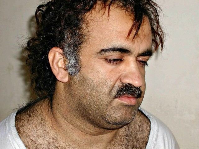 Khalid Sheikh Mohammed with mustache and hairy chest while wearing a white t-shirt