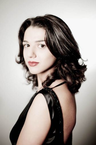 Khatia Buniatishvili smiling closed mouth and wearing a black, sleeveless dress.