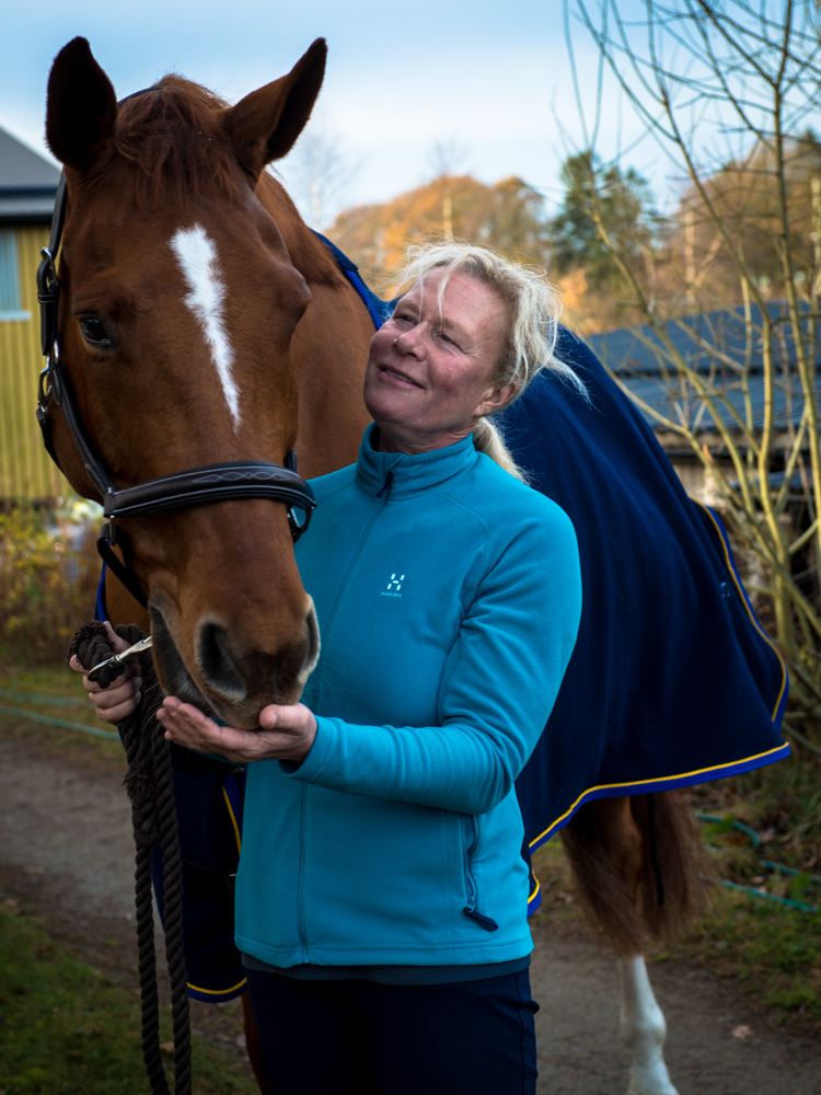 Ulrika Bidegård wearing a blue jacket with her horse