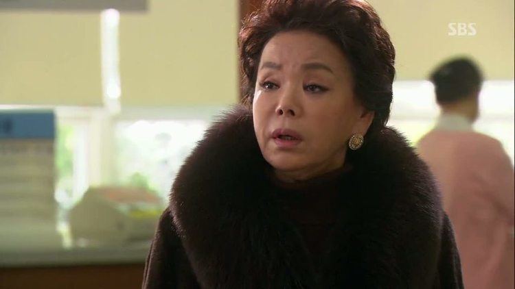 Kim Soo-mi with short hair, wearing earrings and a black fur coat.