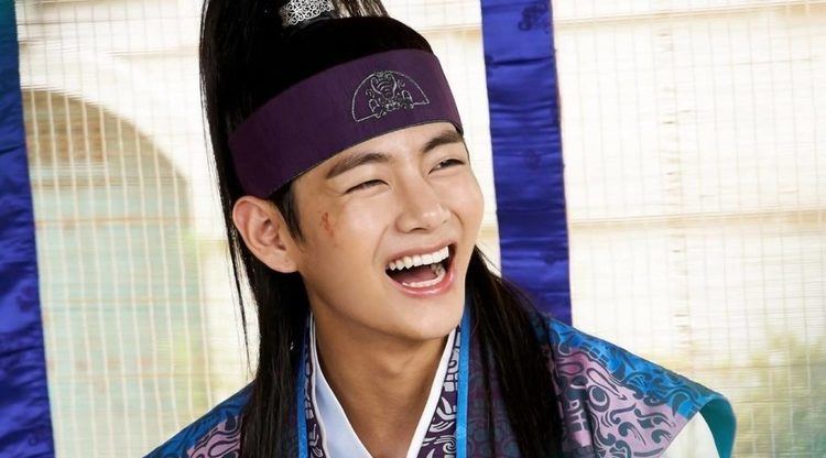 Kim Taehyung as Han Sung, with a big smile on his face and wearing hanbok in a South Korean television series scene from Hwarang (2016-2017).