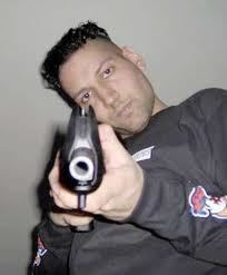 Kimveer Gill holding a gun while wearing a gray sweatshirt