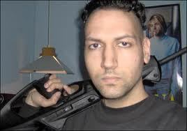 Kimveer Gill holding a berretta Cx4 Storm Semi-Automatic Rifle he used in the shooting while wearing a black t-shirt