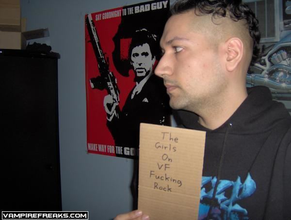 Kimveer Gill with a side-view pose while holding a placard saying, "The girls on VF fucking rock"