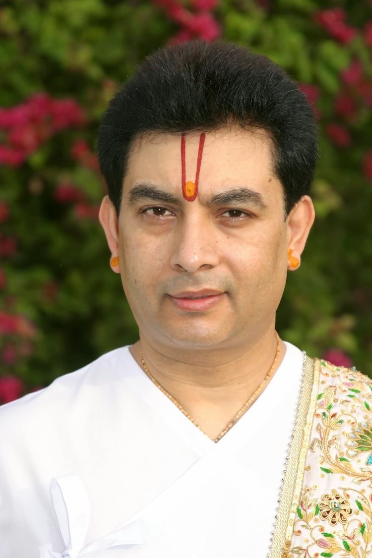 Kirit Bhaiji in white sleeves wearing necklace and earrings