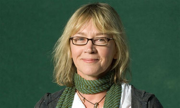 Kitty Aldridge in a green scarf and a pair of glasses
