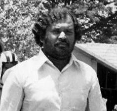Kotwal Ramachandra standing while wearing a white collared shirt
