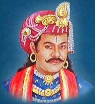Krishnadevaraya with mustache and wearing a pink turban with a gold, white and blue dress, gold earrings, and red and gold scarf