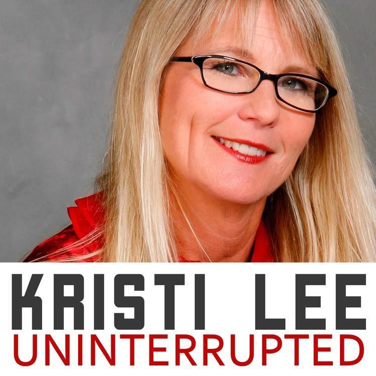 Kristi Lee smiles while wearing a red sleeve and eyeglasses