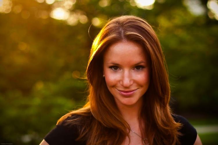 Kristin Fisher smiling and wearing a black shirt.