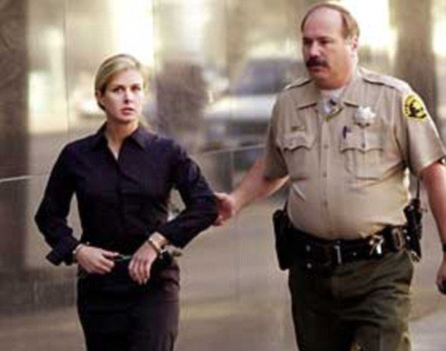 Kristin Rossum walking with a cop beside her