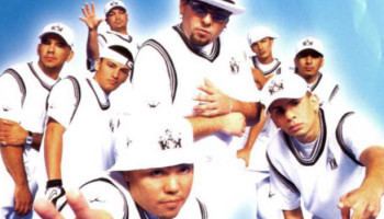 Seven members of Kumbia Kings posing and wearing white basketball clothing.