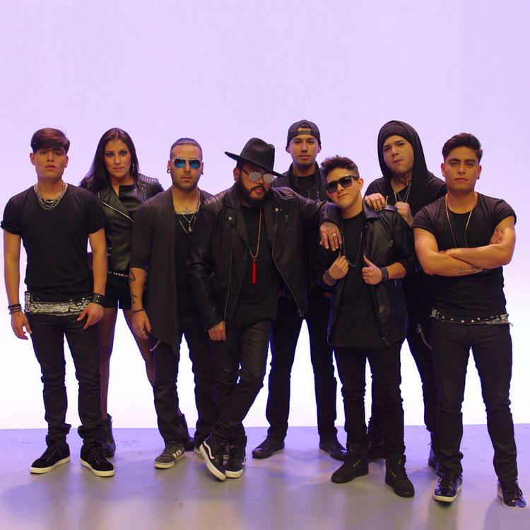 All the current members of Kumbia Kings posing and wearing black clothing and black long pants.