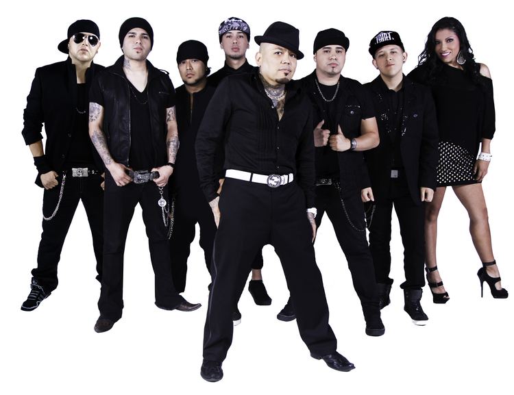 All the current members of Kumbia Kings posing and wearing black clothing and black long pants.