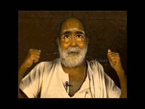 Kunjunni Mash with mustache and beard, wearing eyeglasses and white shirt.