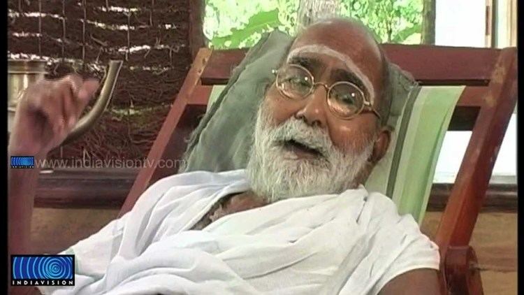 Kunjunni Mash with white mustache and beard, wearing eyeglasses and white shirt.