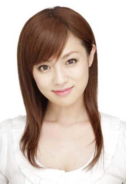 Kyoko Fukada with a tight-lipped smile, brown hair, and side bangs while wearing a white blouse