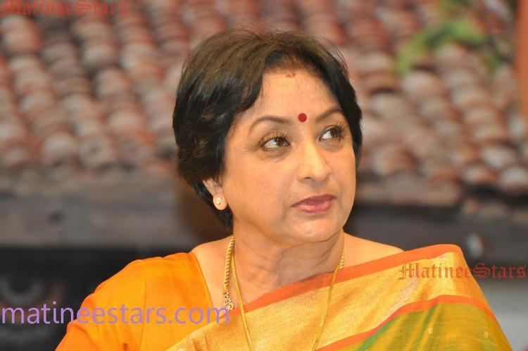 Lakshmi in her orange and gold dress paired with gold necklace