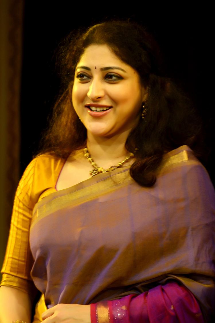 Lakshmi Gopalaswamy wearing gold and violet dress paired with gold necklace and earrings