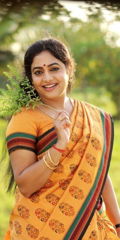 Lakshmi Sharma wearing a dress and holding a plant