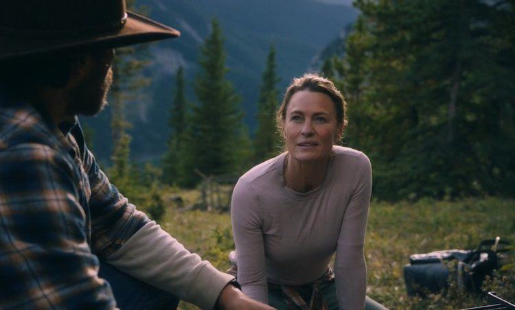 Robin Wright as Edee Holzer talking to Demian Bechir as Miguel Borras and wearing a gray sleeve in a scene from the 2021 movie "Land"