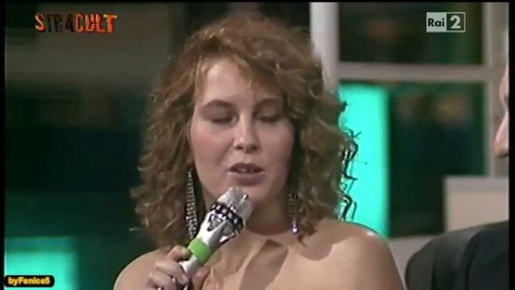 Lara Wendel in her curly hair while holding a microphone