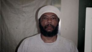 Larry Hoover with mustache and beard while wearing a white bandana and white t-shirt