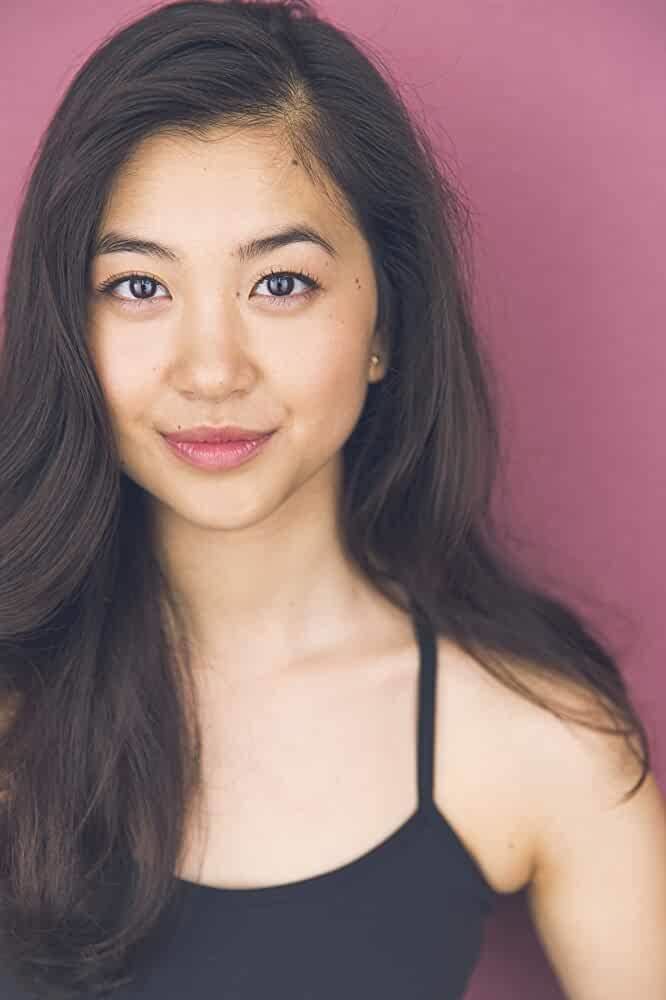 Laura Sohn smiling, with wavy long black hair and wearing a black spaghetti top.