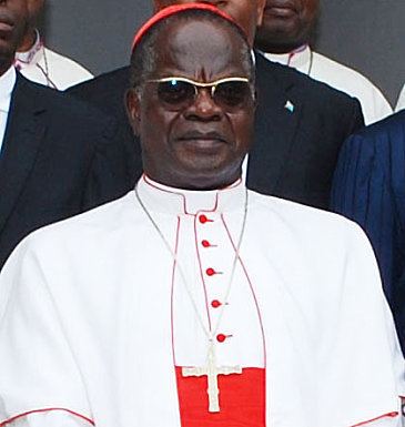 Laurent Monsengwo Pasinya wearing shades, cross necklace, white cassock and red mitre