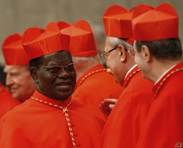 Laurent Monsengwo Pasinya smiling with other Archbishop while wearing eyeglasses, red cassock and red mitre